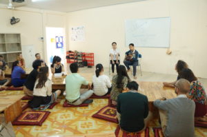 PNV staff and visitors listening to a guitar performance offered by students.