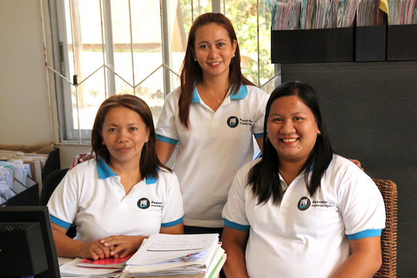 PNP staff in office room standing together smiling.